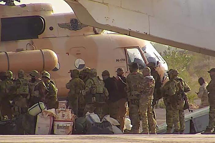 This undated photograph released in April 2022 by France's military shows Russian mercenaries boarding a helicopter in northern Mali.]
