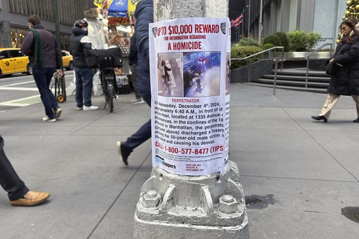 A reward poster hangs on a light pole outside the New York Hilton Midtown Hotel in New York last week. The NYPD offered up to $10,000 for tips leading to the shooting suspect's arrest, while the FBI offered up to $50,000.