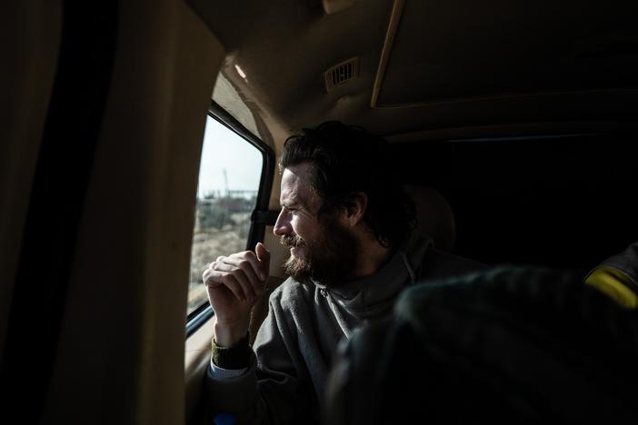 Travis Timmerman looks out the window of a van as he is taken to be handed over to U.S. forces near the Syrian border with Iraq and Jordan on Dec. 13.