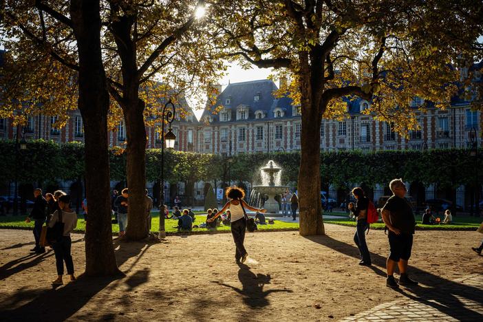 People stroll at Place des Vosges during a sunny afternoon in Paris on Oct. 3, 2023.