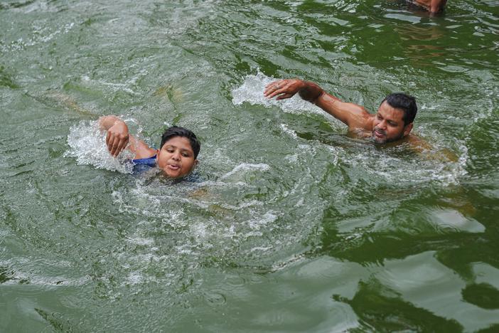 A father teaches his child to swim in a pond in Sylhet, Bangladesh. Drowning is a leading causes of death globally for children, according to the first ever report on drowning as a public health issue issued by the World Health Organization.