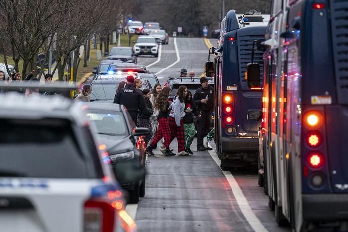 Students from Abundant Life Christian School are escorted to a city bus to be reunited with their parents after a school shooting on Dec. 16, 2024 in Madison, Wis.