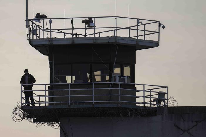 A guard stands in a tower at Indiana State Prison on Tuesday, Dec. 17, 2024, in Michigan City, Ind., where, barring last-minute court action or intervention by Gov. Eric Holcomb, Joseph Corcoran, 49, convicted in the 1997 killings of his brother and three other people, is scheduled to be put to death by lethal injection before sunrise on Wednesday.