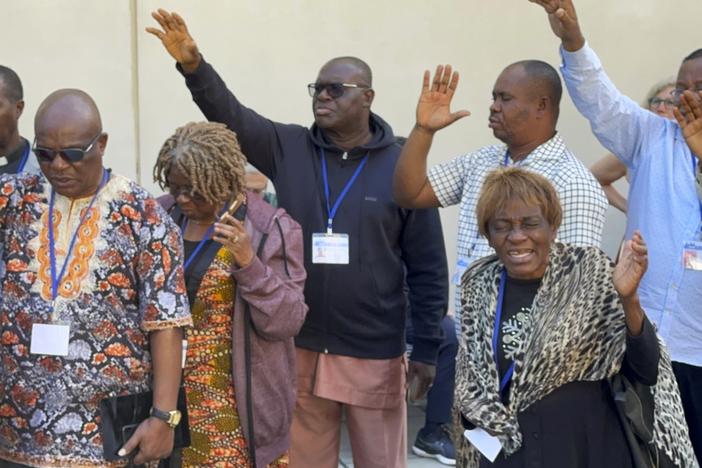 African delegates to the General Conference of the United Methodist Church pray outside the Charlotte Convention Center, in Charlotte, N.C., on May 2, 2024.