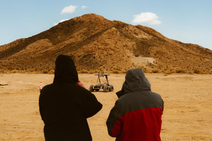 Two people admiring the Helelani rover.