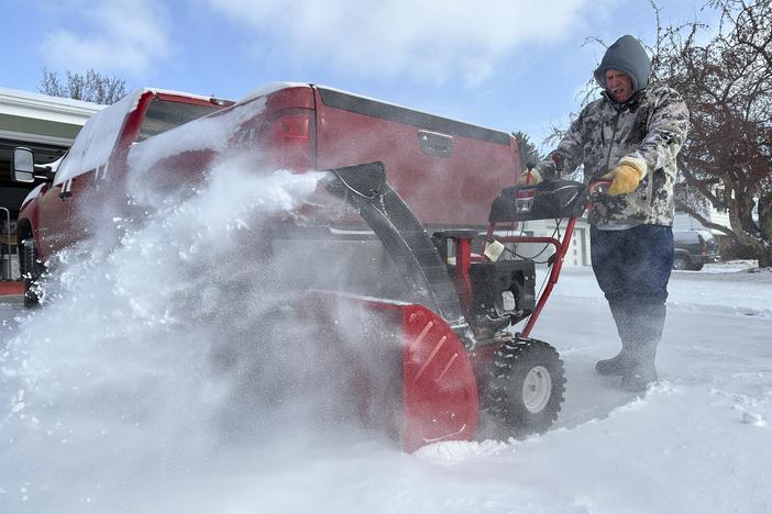Jim Thom clears his driveway of snow with a snowblower on Dec. 19, 2024, in Bismarck, N.D.