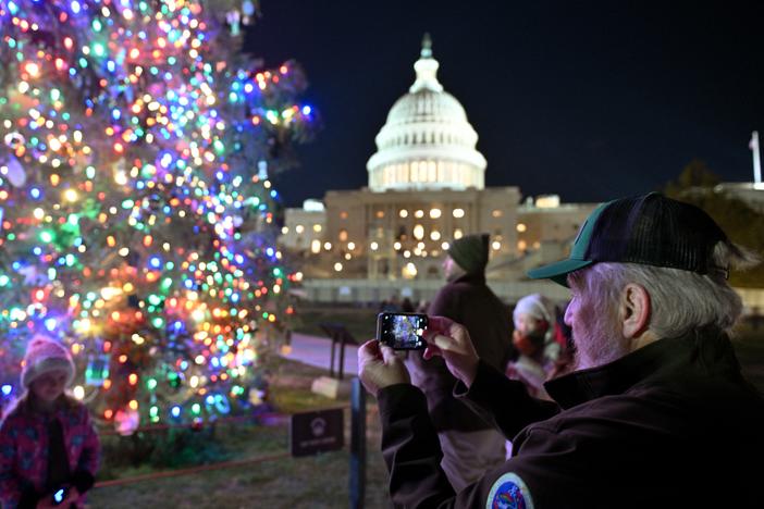The Christmas tree outside the U.S. Capitol is illuminated as Congress works to finalize a stop-gap spending bill to avoid a government shutdown.