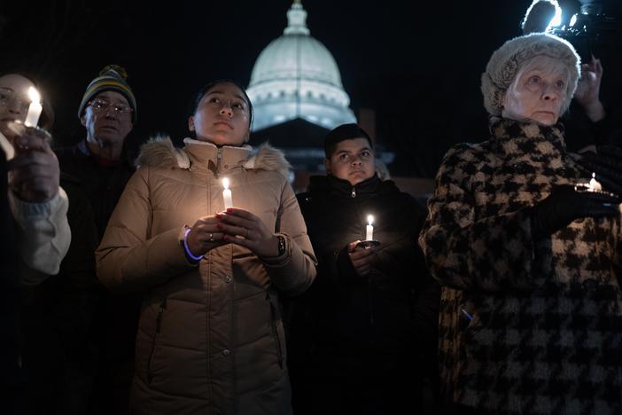People attend a vigil on the grounds of the Wisconsin State Capitol building to mourn the victims of the shooting at Abundant Life Christian School in Madison, Wis.