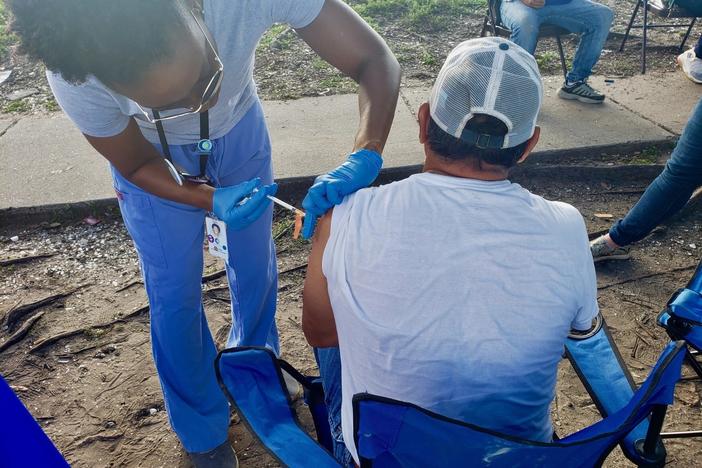 Physician assistant Danis Walker vaccinates a construction worker outside a Lowes Home Improvement store in New Orleans on June 11, 2021.