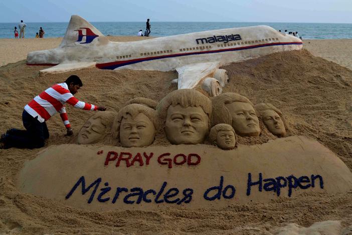 Indian sand artist Sudersan Pattnaik gives final touches on a sand sculpture with a message of prayers for the missing Malaysian Airlines Flight MH370, which vanished from radar early on March 8 somewhere at sea between Malaysia and Vietnam, at Puri Beach, on March 9, 2014.