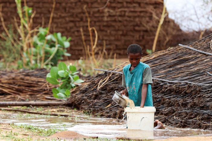 A displaced Sudanese child pours water at Zamzam camp in Darfur, Sudan, Aug. 1. Famine was confirmed in the camp that same month.