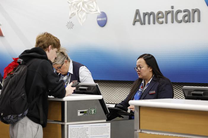 An American Airlines agent talks to a customer at O'Hare International Airport in Chicago, Ill., last week. On Tuesday, the airline issued a national halt to flights.