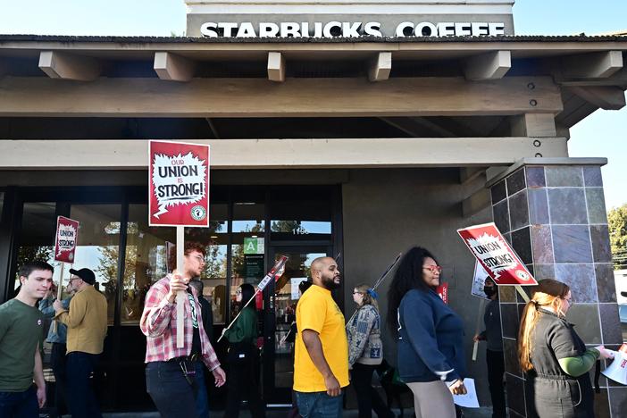 Starbucks workers hold signs as they picket in Burbank, Calif., on Friday.