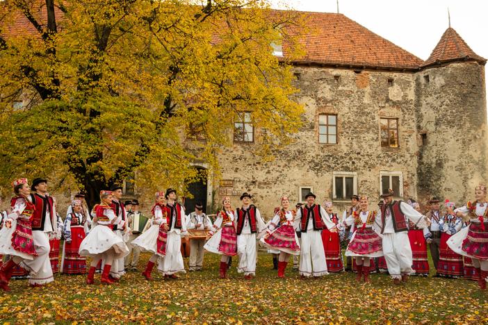The Transcarpathian Folk Choir performs a song and dance for a music video that they are working on to share their music. Ukraine's St. Miklos Castle, which is now an arts exhibit space, a meeting place and museum for local history, provides the backdrop.