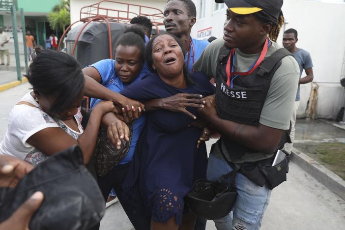 The wife of a journalist, who was shot during an armed gang attack on the General Hospital, cries as an ambulance arrives with his body, at a different hospital in Port-au-Prince, Haiti, on Tuesday.