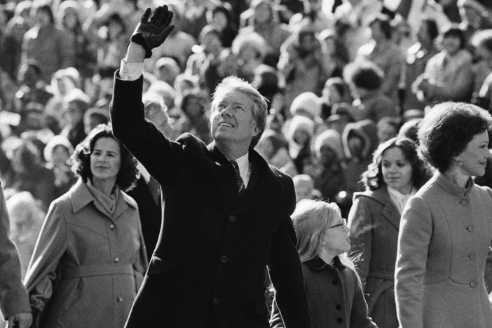 President Jimmy Carter waves to the crowd while walking with his wife Rosalynn and their daughter Amy along Pennsylvania Avenue from the Capitol to the White House following his inauguration, Jan. 20, 1977, in Washington.