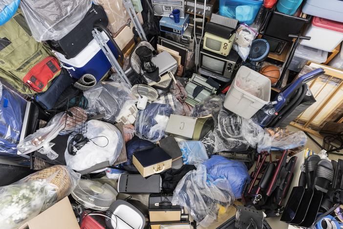 Pile of objects accumulated in someone's home including clothing and outdoor equipment, household objects, and old electronics.