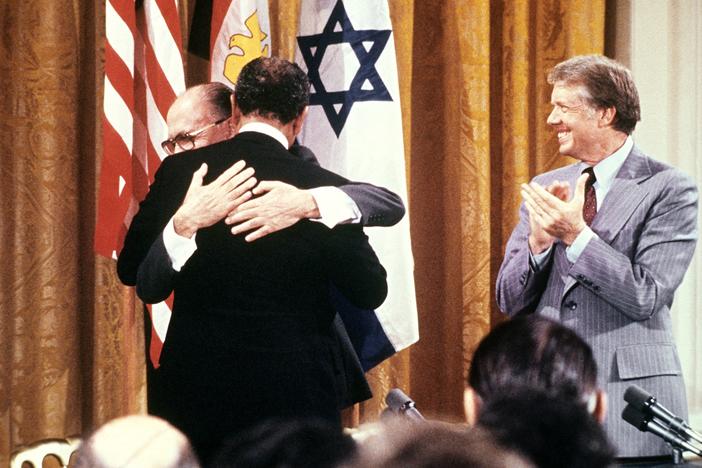 Egyptian President Anwar al-Sadat (back to camera) and Israeli Premier Menachem embrace each other, on Sept. 17, 1978, after signing a peace agreement in the White House with US President Jimmy Carter.