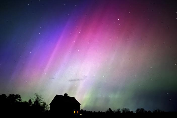 The northern lights flare in the sky over a farmhouse on May 10, 2024, in Brunswick, Maine.