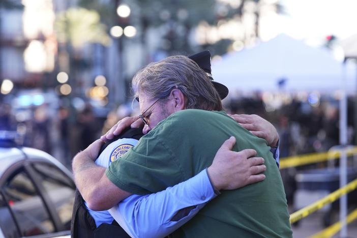 Edward Bruski, right, hugs New Orleans police officer Zachary Stevenson at the scene where a vehicle drove into a crowd on New Orleans' Canal and Bourbon Street.