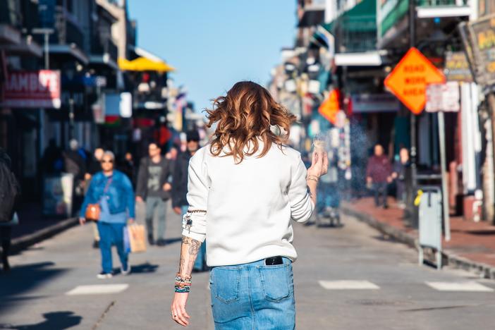 A woman walks down Bourbon Street while burning sage to cleanse the area following the attack.