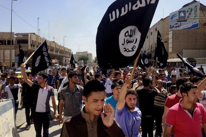 Demonstrators chant pro-Islamic State group slogans as they carry the group's flags in front of the provincial government headquarters in Mosul, Iraq, on June 16, 2014.