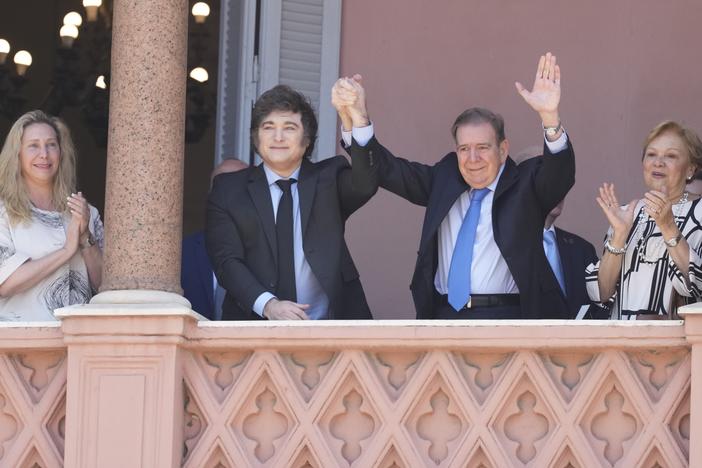 Venezuela's opposition leader Edmundo Gonzalez Urrutia, center right, and Argentine President Javier Milei hold hands from the government house balcony in Buenos Aires, Argentina, Saturday, Jan. 4, 2025.