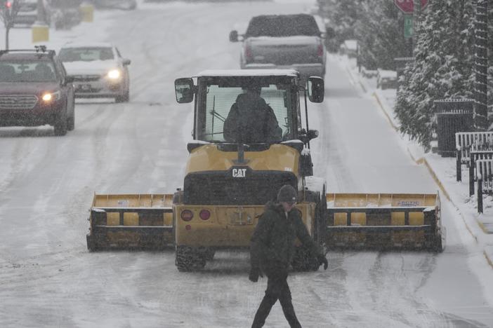 A plow clears a parking lot during a winter storm on Sunday in Cincinnati.