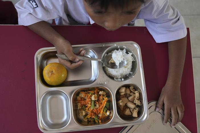 A student has his meal during the kick off of President Prabowo Subianto's ambitious free meal program to feed children and pregnant women nationwide — despite critics saying that its required logistics could hurt Indonesia's state finances and economy — at an elementary school in Depok, West Java, Indonesia, Monday, Jan. 6, 2025.