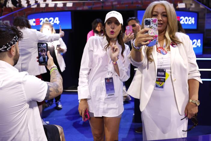 Social media influencers wearing white produce content during the final day of the Democratic National Convention in Chicago on Aug. 22, 2024.
