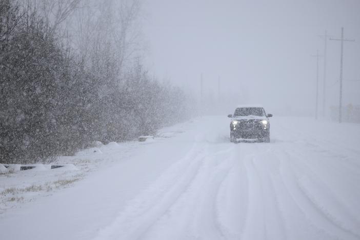 A motorist drives through the snow near Louisville Muhammad Ali International Airport on Sunday in Louisville, Ky. Local forecasts called for heavy snowfall followed by significant accumulation of freezing rain and ice.