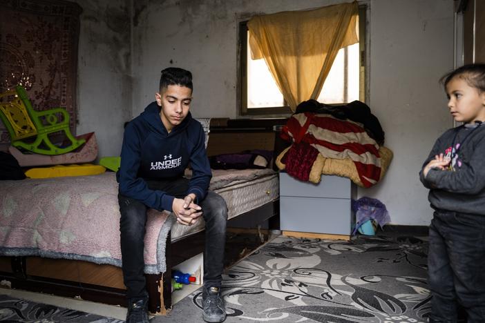 Noor Assi, 15, sits on his bed while watched by his 5-year-old sister Jenna in the village of Qarawat Bani Hassan, Israeli-occupied West Bank, on Feb. 23. <a href="https://www.npr.org/sections/the-picture-show/2024/10/08/g-s1-22630/photos-palestinian-family-impact-israeli-settler-violence-occupied-west-bank"target="_blank"   >Click here for the full story.</a>