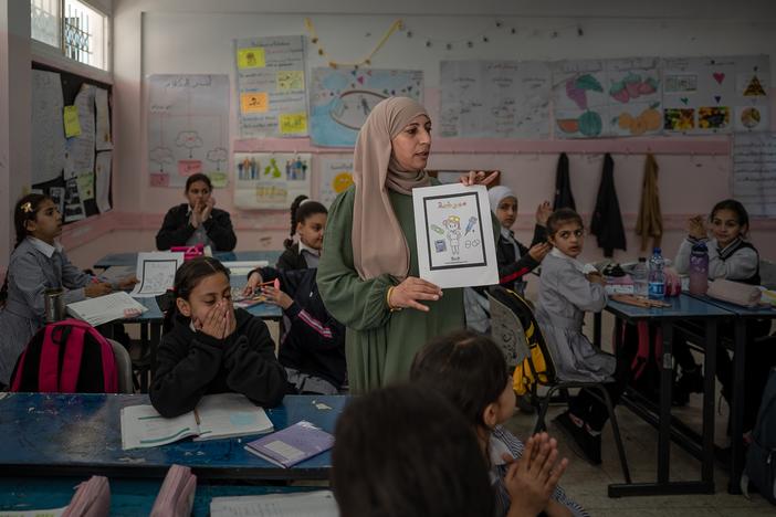 A teacher leads a class at a school for girls administered but the main U.N. agency for Palestinian aid, UNRWA, in Qalandia refugee camp, near Ramallah, in the West Bank, on Nov. 14. <a href="https://www.npr.org/2024/12/03/nx-s1-5205331/israel-palestinians-unrwa-ban-west-bank"target="_blank"   >Click here for the fully story. </a>