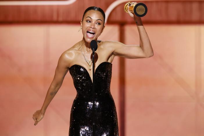 Zoe Saldaña accepts the award for best supporting actress in a motion picture at the Golden Globes Sunday night for her role in the film <em>Emilia Pérez. </em>
