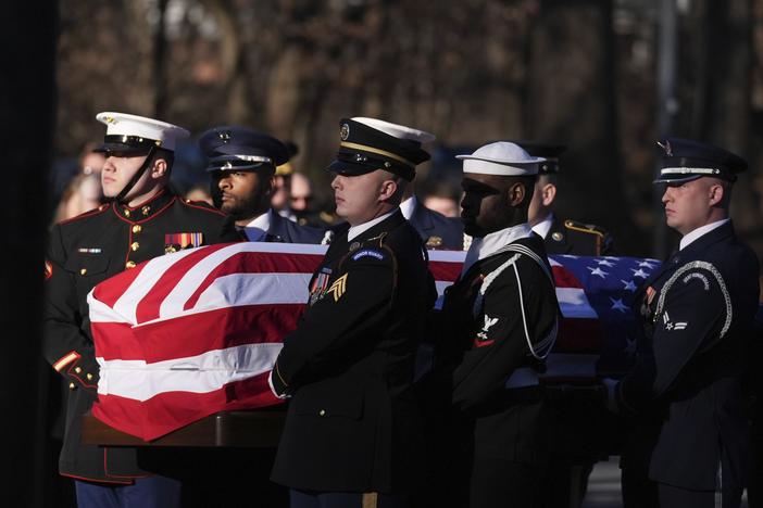 A military body bearer team carries the casket of former President Jimmy Carter into the Jimmy Carter Presidential Library and Museum to lie in repose in Atlanta, Ga.