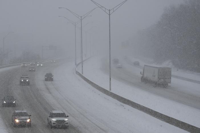Vehicles drive along a highway during a winter storm, Sunday, Jan. 5, 2025, in Cincinnati.