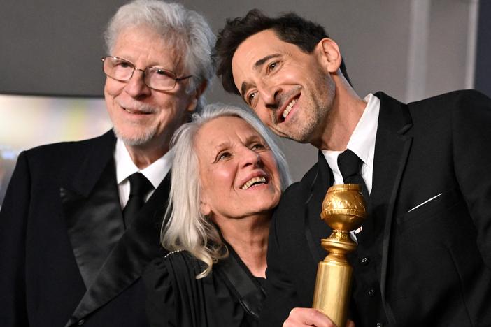 Adrien Brody (R) poses alongside his parents Sylvia Plachy (C) and Elliot Brody (L) in the press room during the 82nd annual Golden Globe Awards.