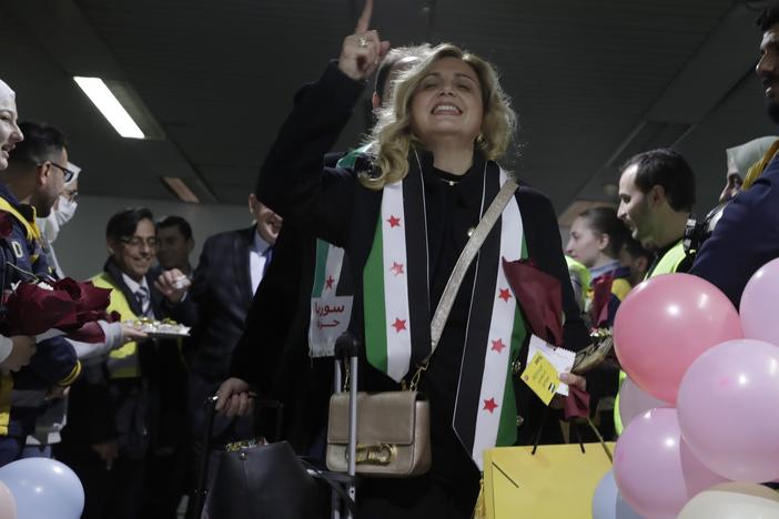 A Syrian woman who arrived at a first international commercial flight since the fall of former Syrian President Bashar Assad shouts anti-Assad slogans at the arrival terminal of Damascus international airport, in Damascus, Syria on Tuesday.