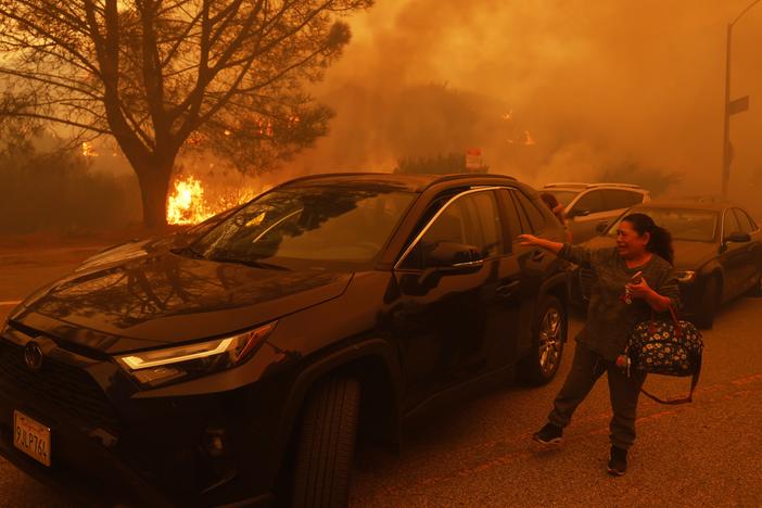 A woman cries as the Palisades Fire advances in the Pacific Palisades neighborhood of Los Angeles Tuesday, Jan. 7, 2025.