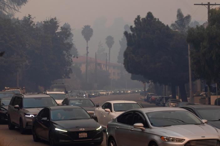 People evacuate on Sunset Boulevard from the Palisades Fire on Jan. 7, 2025 in the Pacific Palisades neighborhood of Los Angeles, Calif.