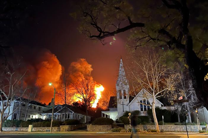 Fire and smoke are visible in the city of Sierra Madre, Calif., Tuesday night.