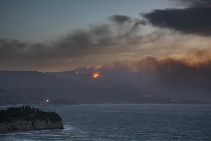 Smoke from the Palisades Fire is seen from Point Dume while it burns homes along the Pacific Coast Highway amid a powerful windstorm on Wednesday in Malibu, California. Fueled by intense Santa Ana winds, the Palisades Fire has burned through thousands of acres while a second major fire continues to burn near Eaton Canyon in Altadena.