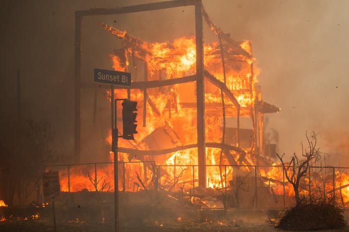 Flames from the Palisades Fire burn a building on Sunset Boulevard amid a powerful windstorm on Wednesday in the Pacific Palisades neighborhood of Los Angeles.