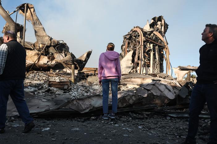 Friday, Jan. 10: Rev. John Shaver (R) looks on while visiting the remains of Community United Methodist Church, where he is pastor.