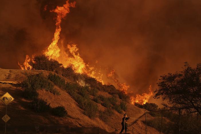 A firefighter battles the Palisades Fire in Mandeville Canyon, north of the Brentwood neighborhood, on Saturday in Los Angeles.