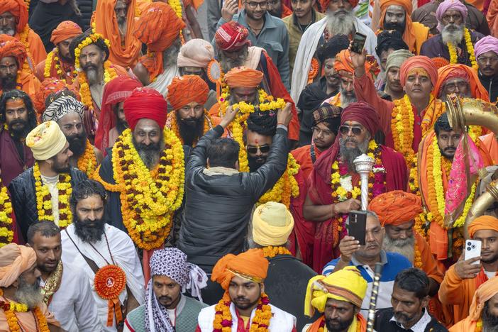 A devotee garlands a senior Hindu holy man walking in a procession, a day before the 45-day-long Maha Kumbh festival, in Prayagraj, India, on Sunday, Jan. 12, 2025.