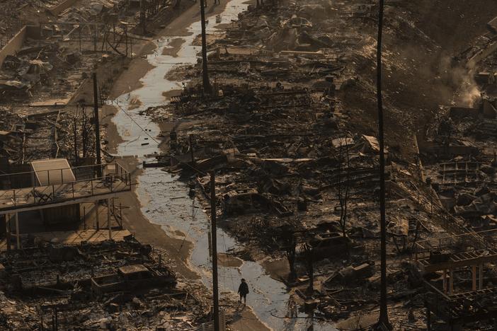 A person walks amid the destruction left behind by the Palisades Fire in the Pacific Palisades neighborhood of Los Angeles, Jan. 9, 2025.