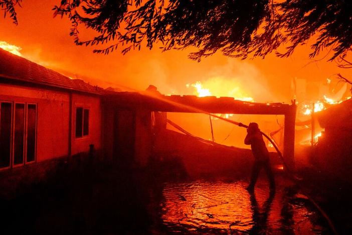 A firefighter douses flames during the Eaton Fire in Pasadena, Calif., on Jan. 8.