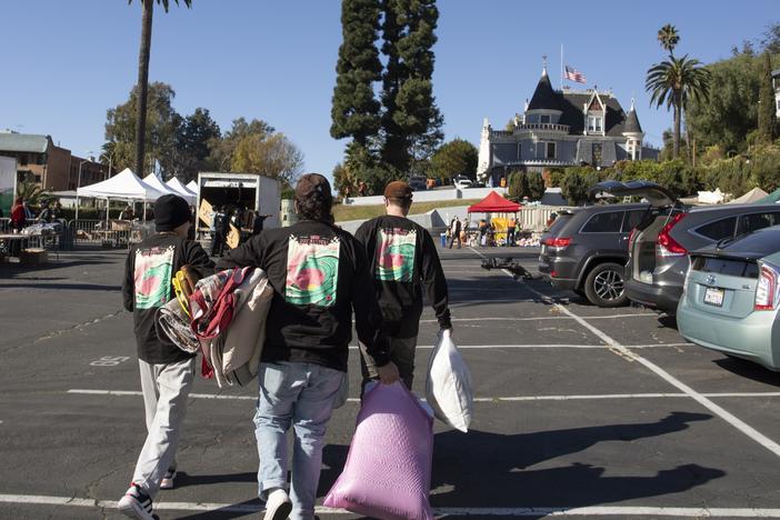 People visit the Magic Castle parking lot in Los Angeles, which has been turned into a donation pick-up and drop off center to help support tens of thousands of wildfire evacuees and victims across the county.