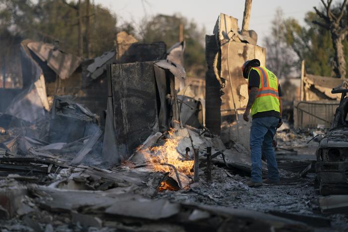 Johnathon Vera with Arizona Pipeline Co. works to extinguish a burning gas line fire in Altadena, Calif., on Jan. 11.